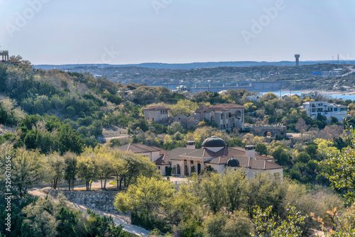 Buildings and trees in Austin Texas with Lake Austin and blue sky background