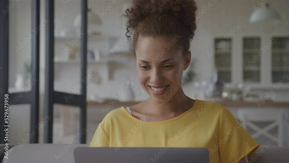 Close up of an African American woman recieving good news celebrating achievement on her laptop