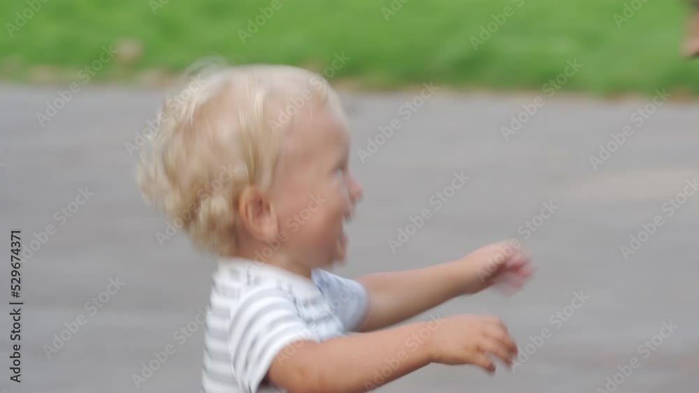 Happy kid running in the park in summer 1.5 year old toddler playing with mother outdoors. Laughing little child having fun playing outside. Happy kid running in the park in summer 1.5 year old toddler playing with mother outdoors. Laughing little child having fun playing outside.