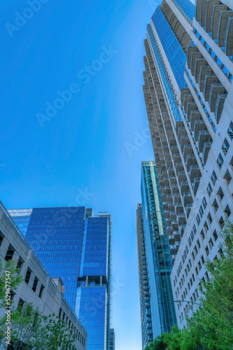 Looking up at apartments with modern geometric architecture against blue sky