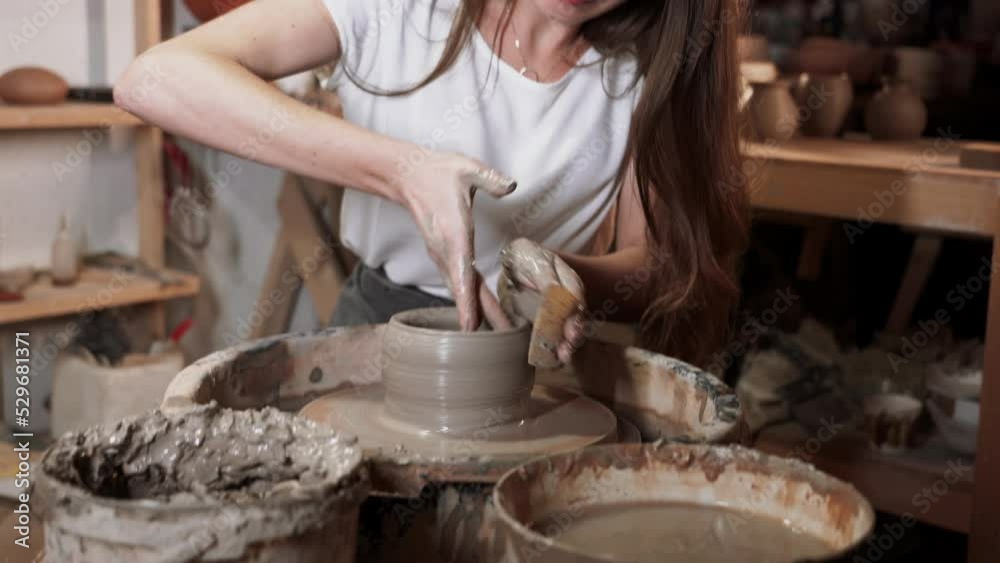 Creative young woman potter with long hair making earthen dishes in workshop.Handmade hobby art and handicraft concept. 4k Creative young woman potter with long hair making earthen dishes in workshop.Handmade hobby art and handicraft concept. 4k