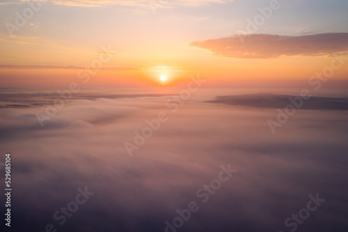 Bird's eye view of the fantastic ocean of clouds at sunrise. Aerial photography, drone shot. © Leonid Tit