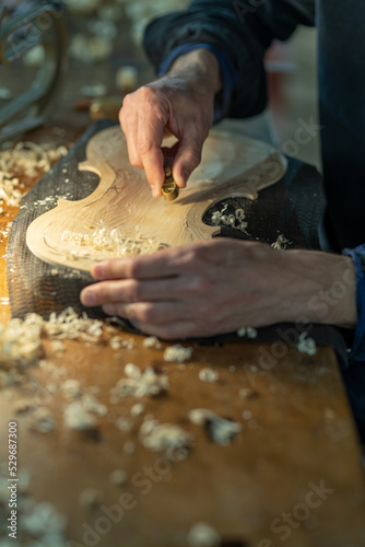 Obraz na płótnie Close up of professional master artisan luthier working on creation of handmade violin in a workshop