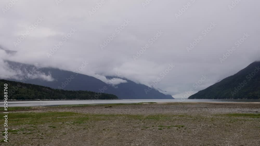 Time Lapse-Wispy cloudy play over the mountain at the Dyea tidal flats. The tidal flat area is a significant feature of the historic landscape of this gold rush boom town Time Lapse-Wispy cloudy play over the mountain at the Dyea tidal flats. The tidal flat area is a significant feature of the historic landscape of this gold rush boom town
