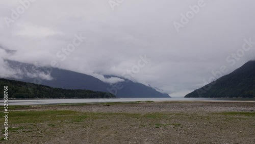 Time Lapse-Wispy cloudy play over the mountain at the Dyea tidal flats. The tidal flat area is a significant feature of the historic landscape of this gold rush boom town photo
