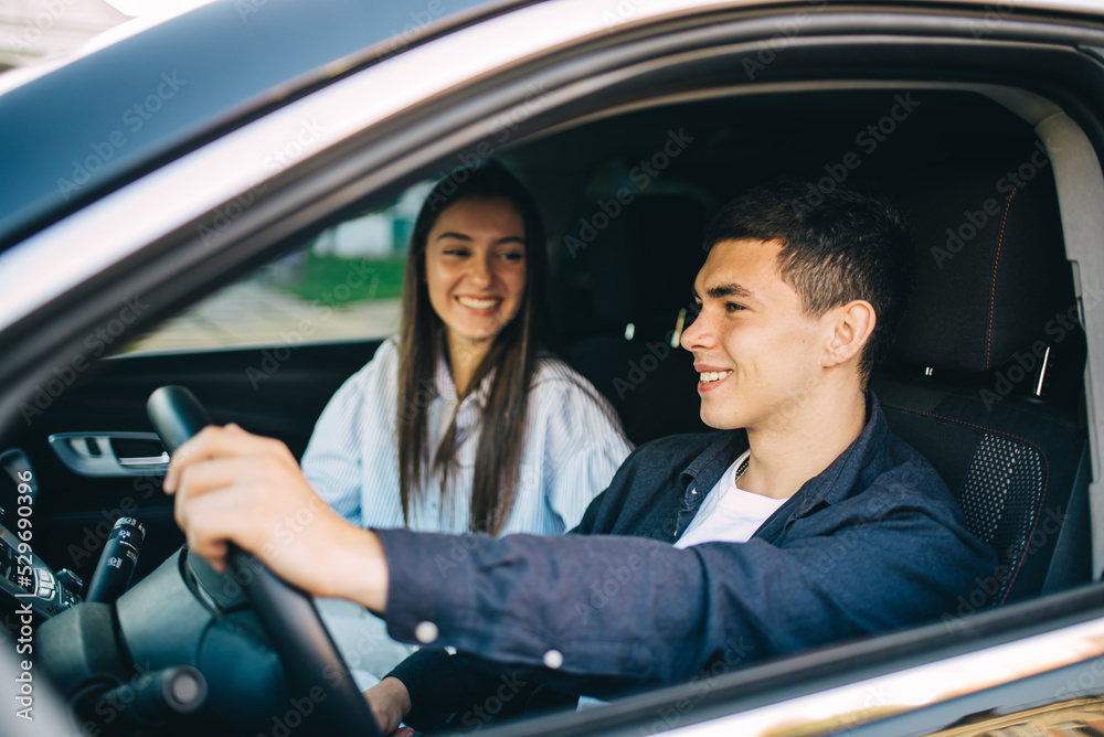 Happy Young Couple Sitting Inside Their Car Enjoying Road Trip, Travel and Adventure Concept Happy Young Couple Sitting Inside Their Car Enjoying Road Trip, Travel and Adventure Concept