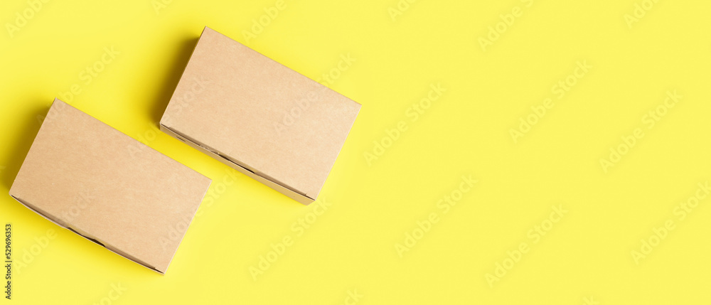 Blank cardboard boxes on yellow background with space for text, top view Blank cardboard boxes on yellow background with space for text, top view