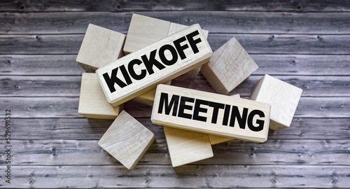 Kickoff meeting text on wooden blocks on wooden background .Money, business and finance concept