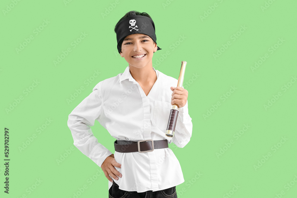 Little boy dressed as pirate with spyglass on green background Little boy dressed as pirate with spyglass on green background