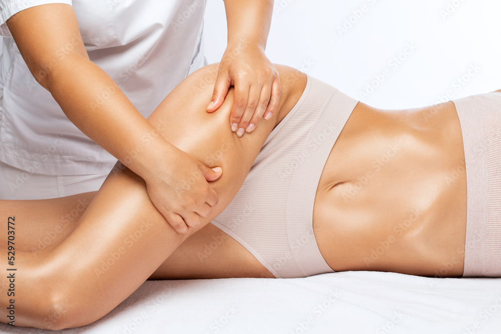 Masseur makes anti-cellulite massage on the legs, thighs, hips and buttocks in the spa. Overweight treatment, body sculpting.Cosmetology and massage concept. Masseur makes anti-cellulite massage on the legs, thighs, hips and buttocks in the spa. Overweight treatment, body sculpting.Cosmetology and massage concept.