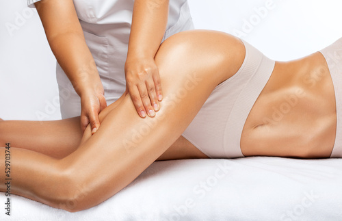 Masseur makes anti-cellulite massage on the legs, thighs, hips and buttocks in the spa. Overweight treatment, body sculpting.Cosmetology and massage concept.