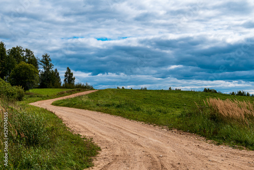 A rocky road with a bend leads up a hill.