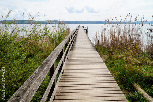 a long wooden pier on lake Ammersee in the beautiful Bavarian village Schondorf (Bavaria, Germany) 
