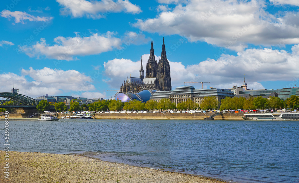 Naklejka premium Cologne, Germany - July 9. 2022: View over river rhine on gothic dom towers and musical dome in summer