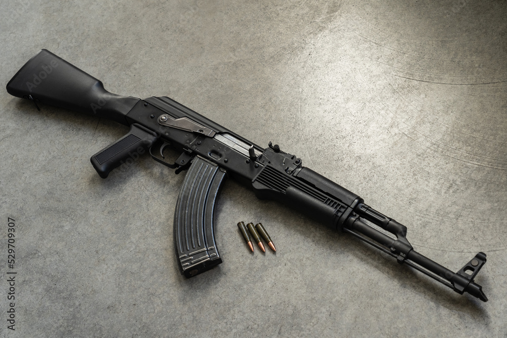 Russian weapon, ak 47 with a plastic butt and forearm against the background of concrete, close-up photo.