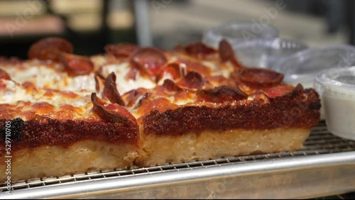 This close up video shows a side view of a delicious, freshly made Detroit style pizza.