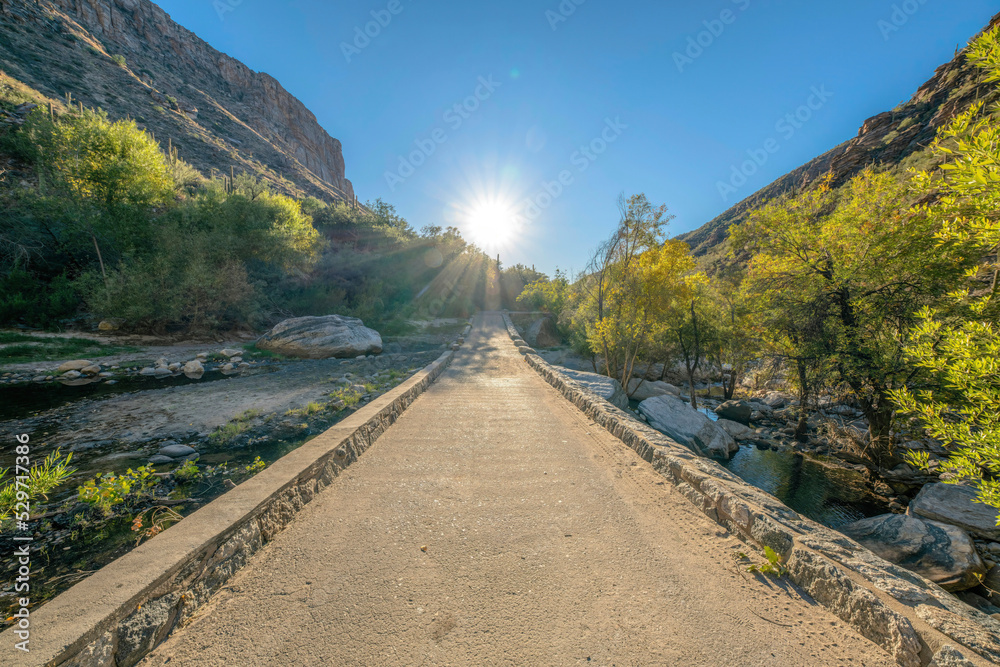 Sun above the straight concrete bridge over the creek in Sabino Canyon State Park, Tucson, AZ