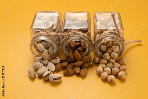 Mix of nuts: almonds, pistachios and hazelnuts on a yellow background. Template