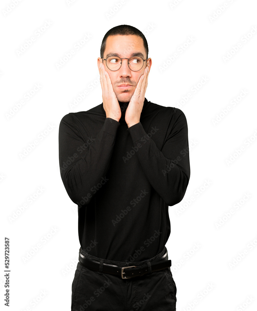 Concerned young man doing a gesture of relief Concerned young man doing a gesture of relief