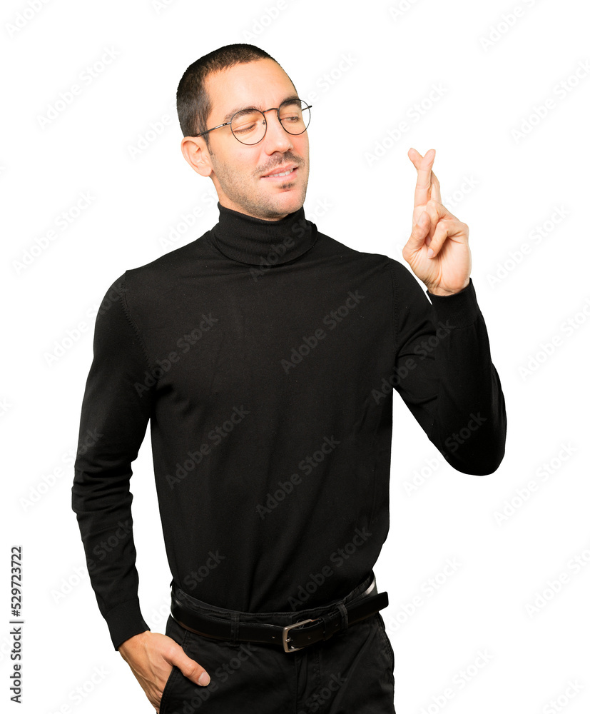 Happy young man doing a crossed fingers gesture Happy young man doing a crossed fingers gesture