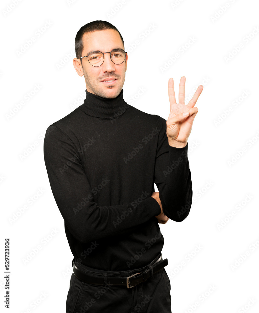 Young man making a number three gesture Young man making a number three gesture