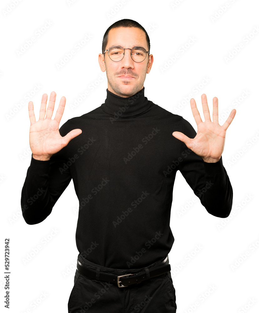 Fototapeta premium Young man making a number ten gesture