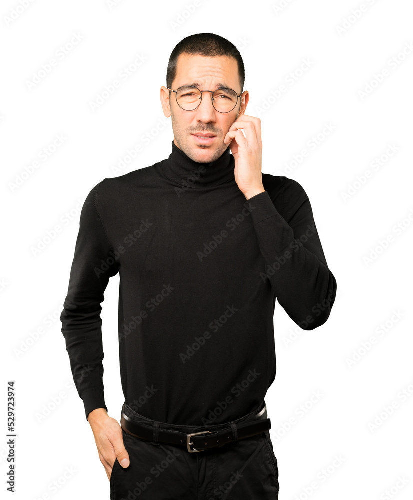 Concerned young man making a scratching gesture Concerned young man making a scratching gesture