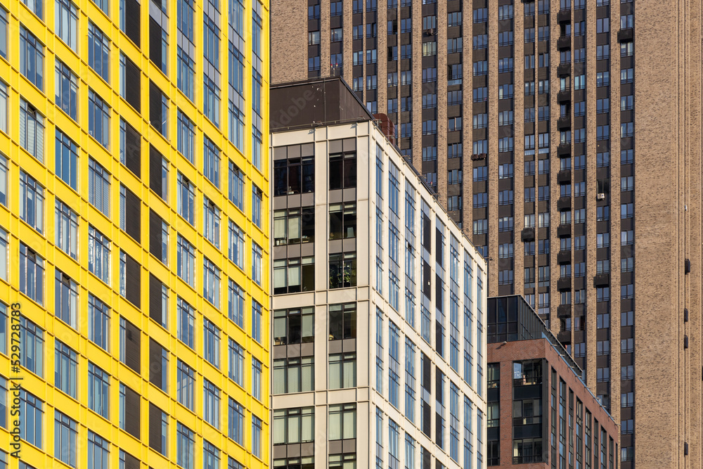 Fototapeta premium Rows of windows in residential skyscrapers. Dense rows of modern high-rise residential buildings. The problems of urban overpopulation. Residential skyscrapers