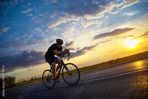 Tablou canvas Young sports man cycling with bicycle on the road in summer