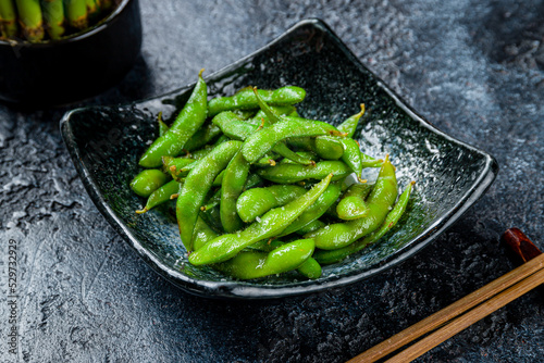 edamame beans on dark plate on dark stone table photo