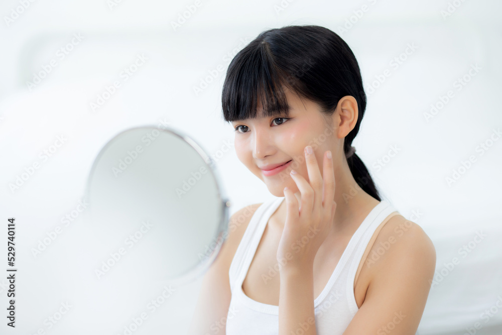 Beautiful face of young asian woman with happy smiling and touch cheek looking mirror with charming, makeup of beauty facial girl with skincare and cosmetic treatment, skin care and healthy concept. Beautiful face of young asian woman with happy smiling and touch cheek looking mirror with charming, makeup of beauty facial girl with skincare and cosmetic treatment, skin care and healthy concept.