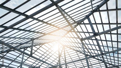 Steel roof structure of house. Construction site and sunset background.