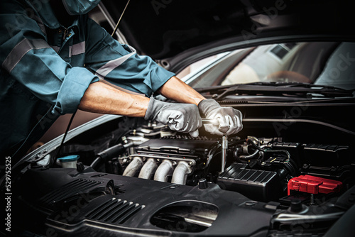 Car care maintenance and servicing, Close-up hand technician auto mechanic using the wrench to repairing change spare part car engine problem and car insurance service support. © Eakrin