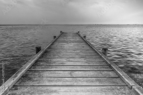 Wooden dock entering the sea. End of summer concept. Autumn wallpaper and background