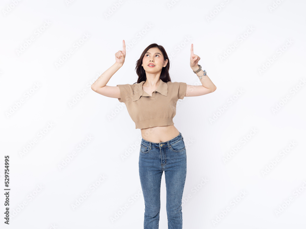 portrait of a Happy Asian woman smiling points her index finger at an empty space in the background and looks straight ahead on white background portrait of a Happy Asian woman smiling points her index finger at an empty space in the background and looks straight ahead on white background
