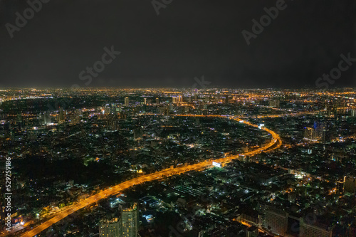 Aerial view of highway street road at Bangkok Downtown Skyline  Thailand. Financial district and business centers in smart urban city in Asia. Skyscraper and high-rise buildings at night.