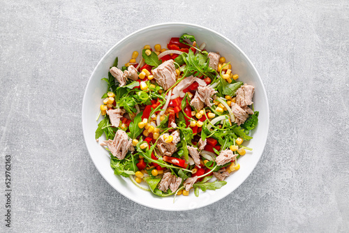 Foto Canned tuna salad with arugula and fresh vegetables, top view