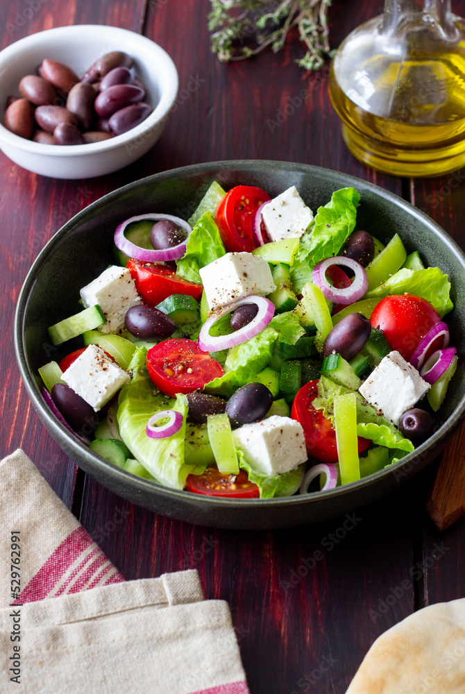 Greek salad with feta cheese, tomatoes, cucumbers, peppers and Kalamata olives. Healthy eating. Vegetarian food.