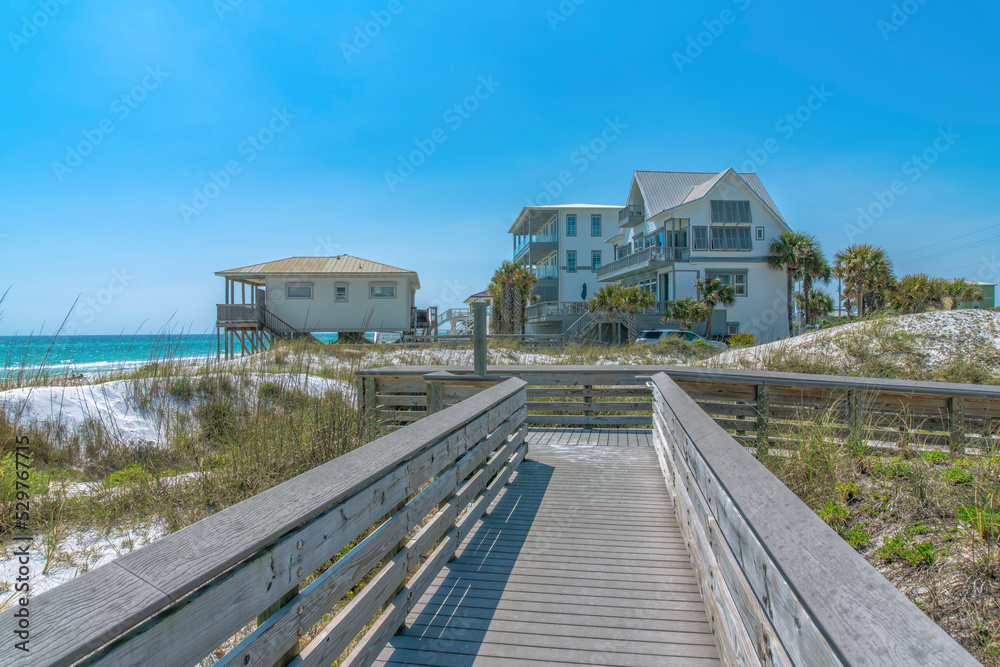 View of beach houses from a wooden boardwalk on a beach at Destin, Florida