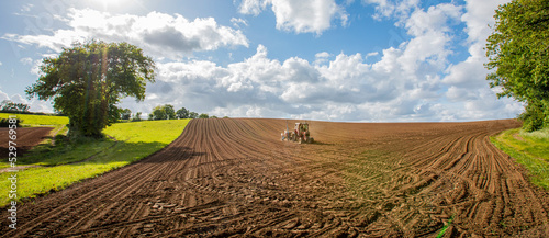 Tracteur dans le champs en train de semer le blé au printemps.