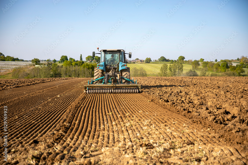Agriculteur semant le champ labouré au printemps dans la campagne en France. Agriculteur semant le champ labouré au printemps dans la campagne en France.