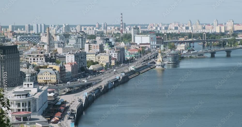 View of the big city. Wide road with moving cars. The sky, high-rise buildings, a wide river with bridges. Kyiv, Ukraine, Europe, daytime. View of the big city. Wide road with moving cars. The sky, high-rise buildings, a wide river with bridges. Kyiv, Ukraine, Europe, daytime.