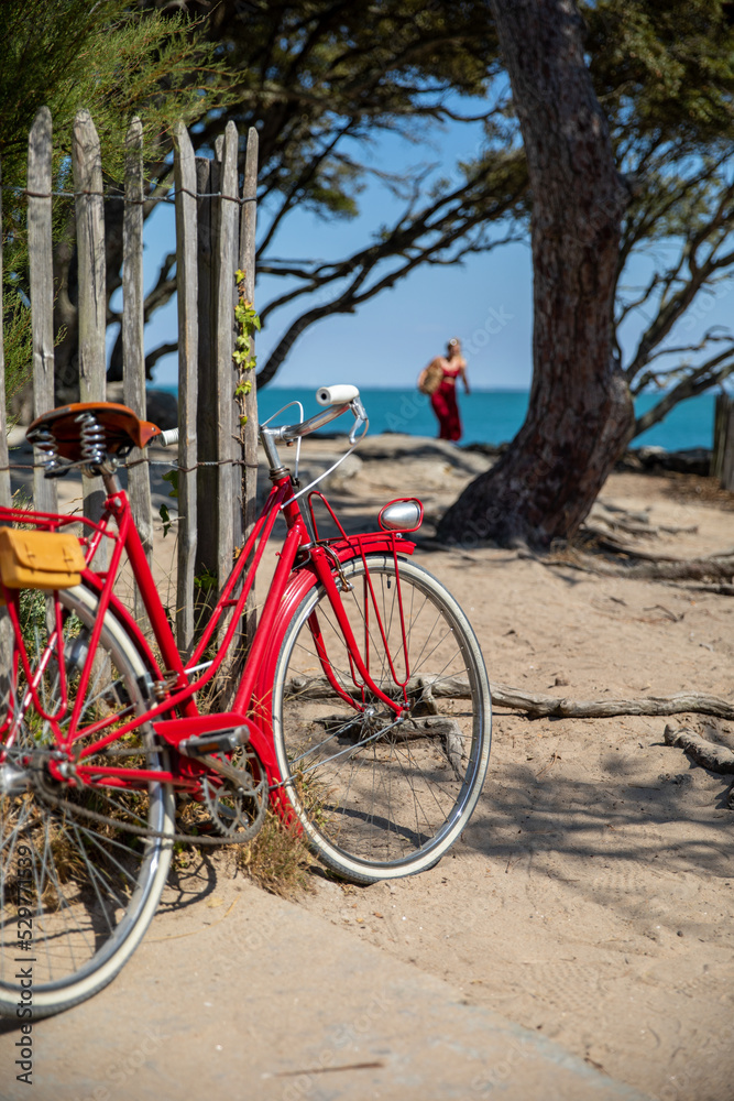 Vieux vélo rouge sur une plage en France.