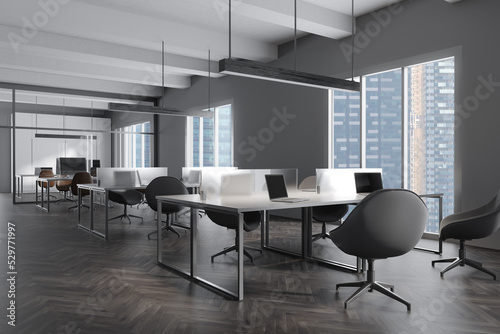 Grey office interior with laptop and pc computer, panoramic window © ImageFlow