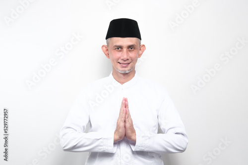 Portrait Asian Moslem Man with greetings and welcoming gestures ,smiling face 