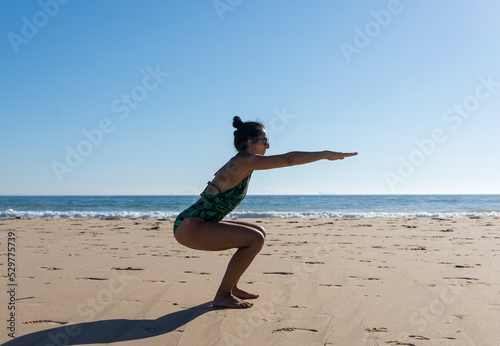 Yoga woman doing yoga pose on the beach for wellbeing health lifestyle.