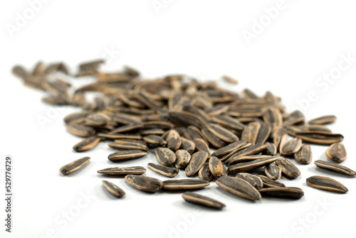 A pile of sunflower seeds on a white floor, selective focus.