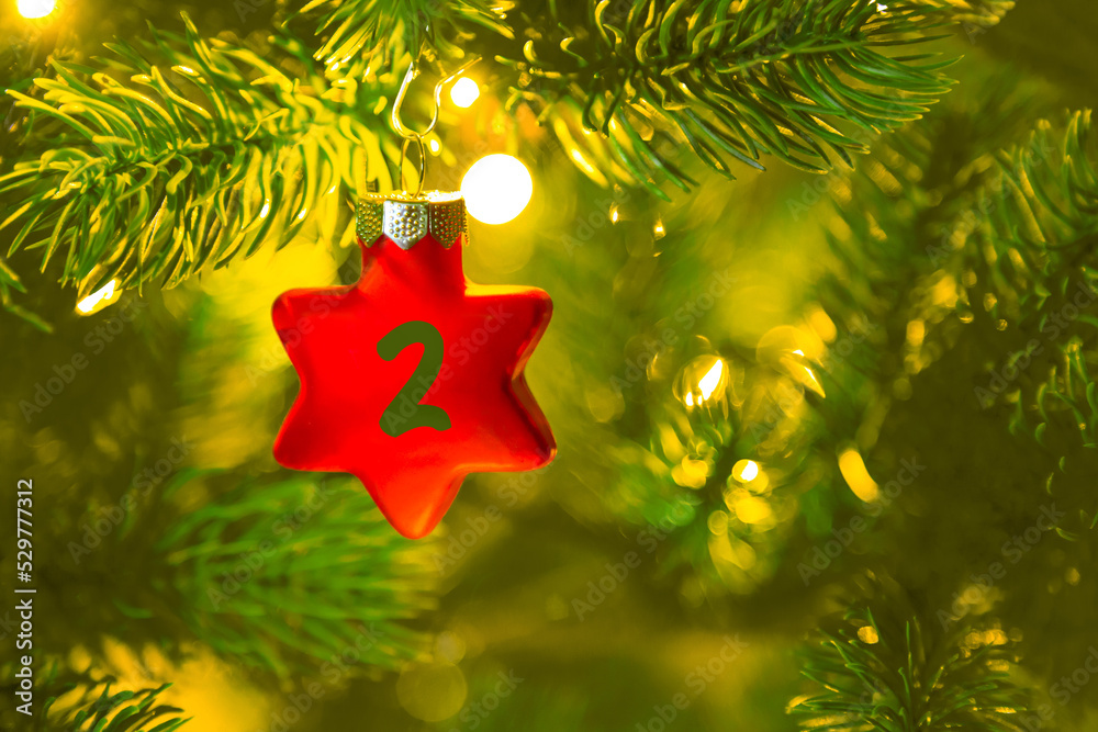 ein roter Stern mit einer Zahl (2) am Weihnachtsbaum, Weihnachtskalender