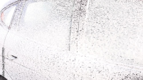 someone washes a car with foam at a car wash