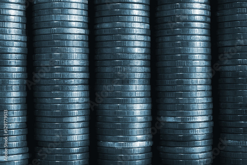 Stack of coins close-up. Coin texture. Blue tinted business background made of many coin edge. Economy finance and bank backdrop. Abstract money wall. Tax, credit and currency change. Macro